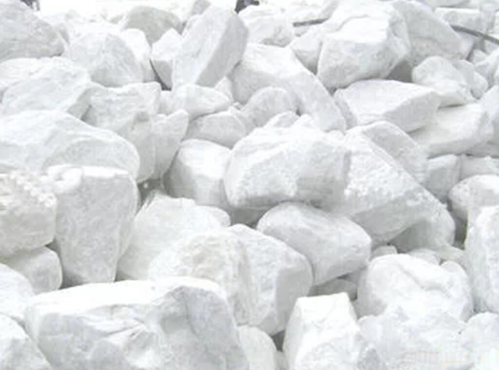 Pile of high-purity white calcium carbonate rocks prepared for industrial processing.