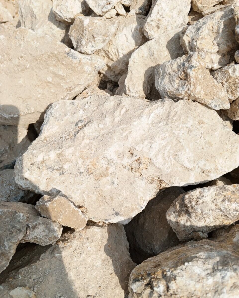 Raw coarse barite mineral stones (BaSO₄) in beige and white tones used for drilling, chemicals and industrial applications.