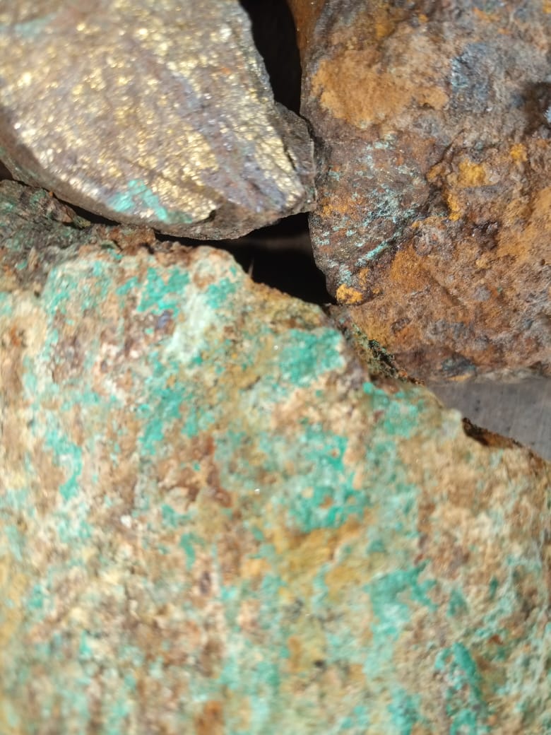 Raw copper ore stones showing green, blue and brown mineral formations used in metallurgy and industrial copper extraction.